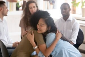 participants hug each other during support group at detox in Orange County, CA